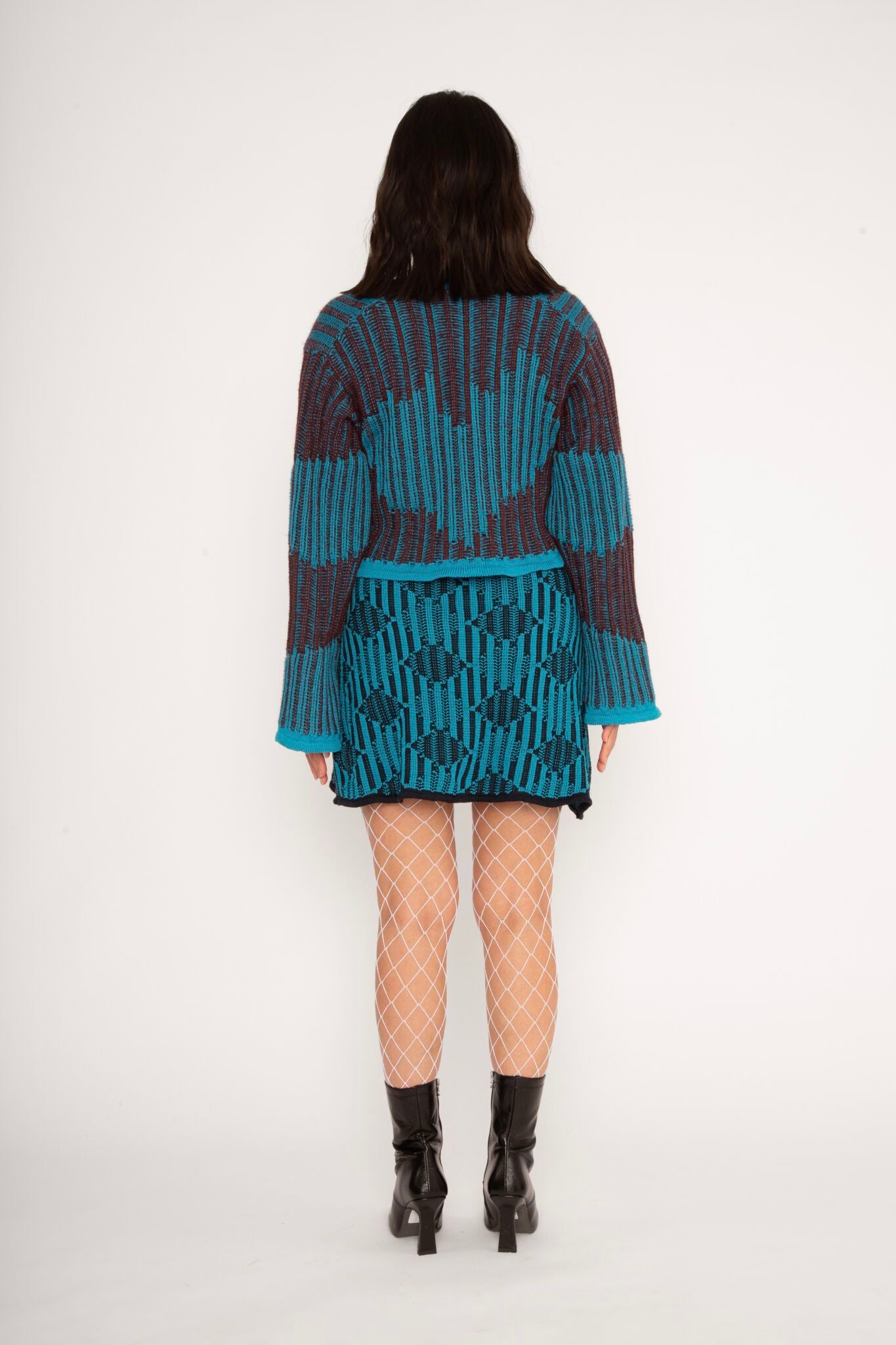 Wavy Wool Cardigan in turquoise and cherry red is a knitted cropped mohair cardigan with flared sleeves and all-over wavy stripes. Detailed with a heart in the back. The cardigan has a ribbed V-shaped neckline, a three-button closure and is cut for a slightly loose fit. The textile is fluffy, non-itchy and comfortable against the skin. The Wavy Wool Cardigan is also available in red and comes in 3 different sizes.