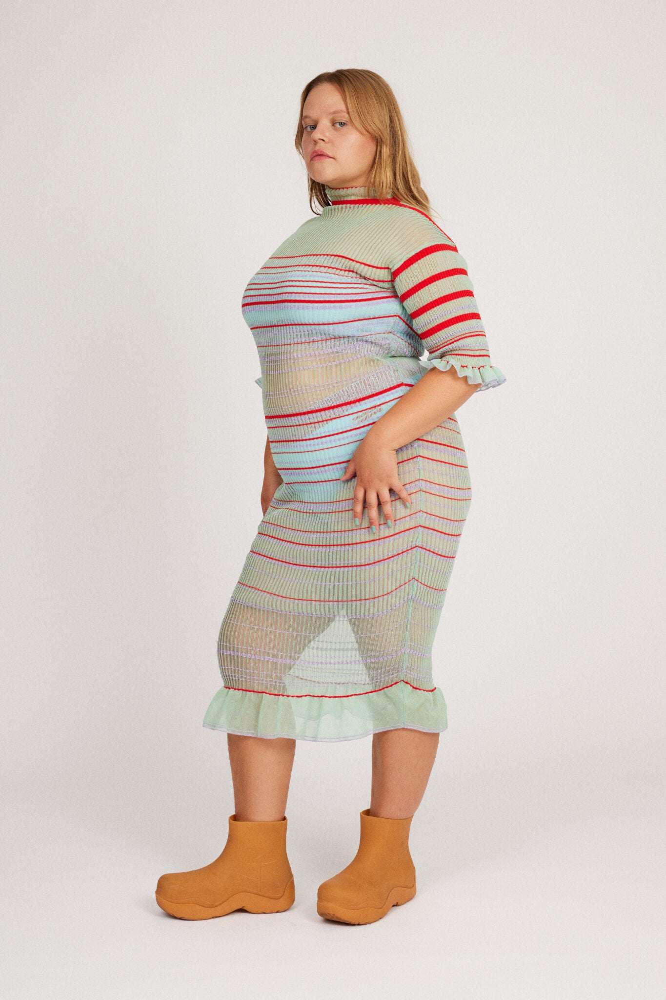 Sweet Secret Dress in mint green is a transparent knitted short sleeved high neck dress in gradient stripes with shimmery metallized yarn. The textile is lightweight, delicate and very flexible. The dress has a body fitted silhouette that adapts to the body.