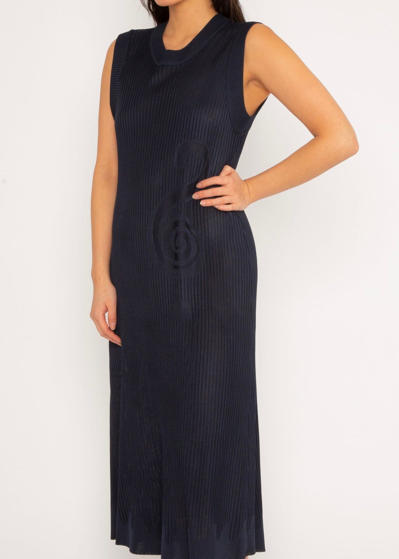 Spiral Dress in navy is a knitted flared crew neck dress with spiral artwork. The dress has an A-line cut and a slightly loose fit. The textile has a shine to it and is lightweight with a smooth and soft feel against the body. Detailed with ribbed rims and wavy artwork in the bottom. The Spiral Dress is available in 3 different sizes.