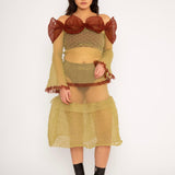 Bubble Bell Top in khaki and cherry red is a transparent knitted off-shoulder top in a ribbed bubble texture with ruffles and bell sleeves. The top has a close fit body with long sleeves and a voluminous adjustable neckline detailed with a melange rim with a logo in the back. The textile is lightweight, delicate and very flexible, meaning the dress adapts to body wearing it. The Bubble Bell Top is also available in teal and comes in 2 different sizes.