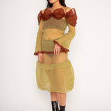 Bubble Bell Top in khaki and cherry red is a transparent knitted off-shoulder top in a ribbed bubble texture with ruffles and bell sleeves. The top has a close fit body with long sleeves and a voluminous adjustable neckline detailed with a melange rim with a logo in the back. The textile is lightweight, delicate and very flexible, meaning the dress adapts to body wearing it. The Bubble Bell Top is also available in teal and comes in 2 different sizes.