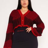 Wavy Wool Cardigan in red and black is a knitted cropped mohair cardigan with flared sleeves and all-over wavy stripes. Detailed with a heart in the back. The cardigan has a ribbed V-shaped neckline, a three-button closure and is cut for a slightly loose fit. The textile is fluffy, non-itchy and comfortable against the skin. The Wavy Wool Cardigan is also available in turquoise and comes in 3 different sizes.
