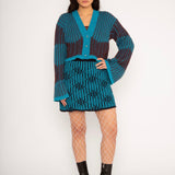 Wavy Wool Cardigan in turquoise and cherry red is a knitted cropped mohair cardigan with flared sleeves and all-over wavy stripes. Detailed with a heart in the back. The cardigan has a ribbed V-shaped neckline, a three-button closure and is cut for a slightly loose fit. The textile is fluffy, non-itchy and comfortable against the skin. The Wavy Wool Cardigan is also available in red and comes in 3 different sizes.