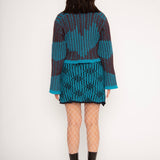Wavy Wool Cardigan in turquoise and cherry red is a knitted cropped mohair cardigan with flared sleeves and all-over wavy stripes. Detailed with a heart in the back. The cardigan has a ribbed V-shaped neckline, a three-button closure and is cut for a slightly loose fit. The textile is fluffy, non-itchy and comfortable against the skin. The Wavy Wool Cardigan is also available in red and comes in 3 different sizes.