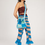 Twisted Frill Bag in blue and mint green is a knitted transparent crossbody cinch bag in twisted chess stripes. Detailed with ruffles, a logo jacquard strap and an adjustable opening.