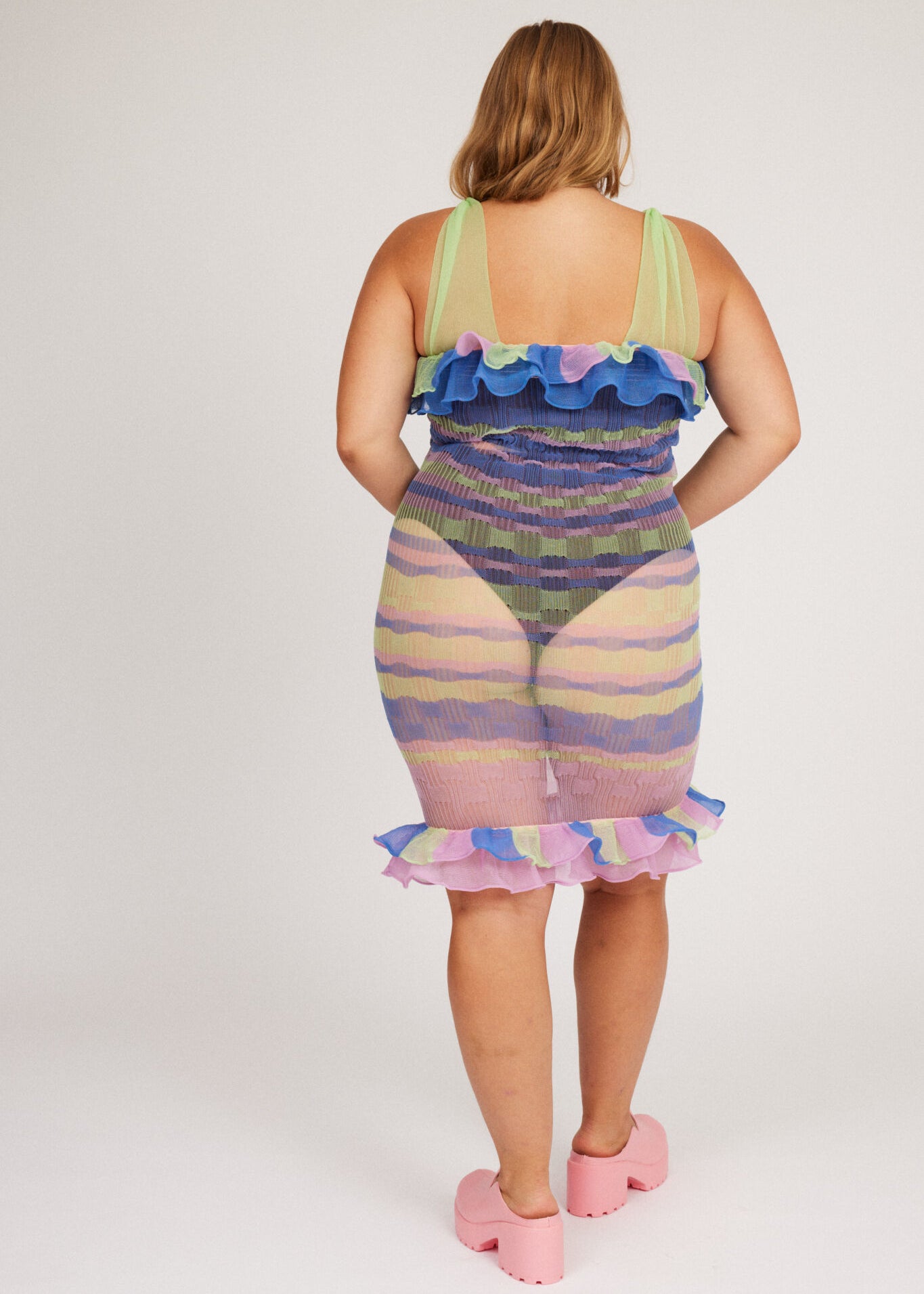 Loveable Dress in lilac and green is a transparent knitted strap dress in bold stripes with a ribbed bubble texture. The textile is lightweight, delicate and very flexible. The dress has a body fitted silhouette that adapts to the body. Detailed with frills.