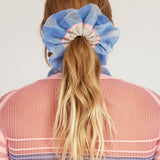 Petunia Scrunchie in powder blue and pink is a knitted scrunchie in bold stripes. Made of transparent and shimmery yarns.