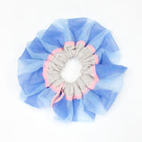 Petunia Scrunchie in powder blue and pink is a knitted scrunchie in bold stripes. Made of transparent and shimmery yarns.