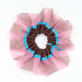 Petunia Scrunchie in tanned and pink is a knitted scrunchie in bold stripes. Made of transparent and shimmery yarns.