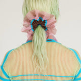 Petunia Scrunchie in tanned and pink is a knitted scrunchie in bold stripes. Made of transparent and shimmery yarns.