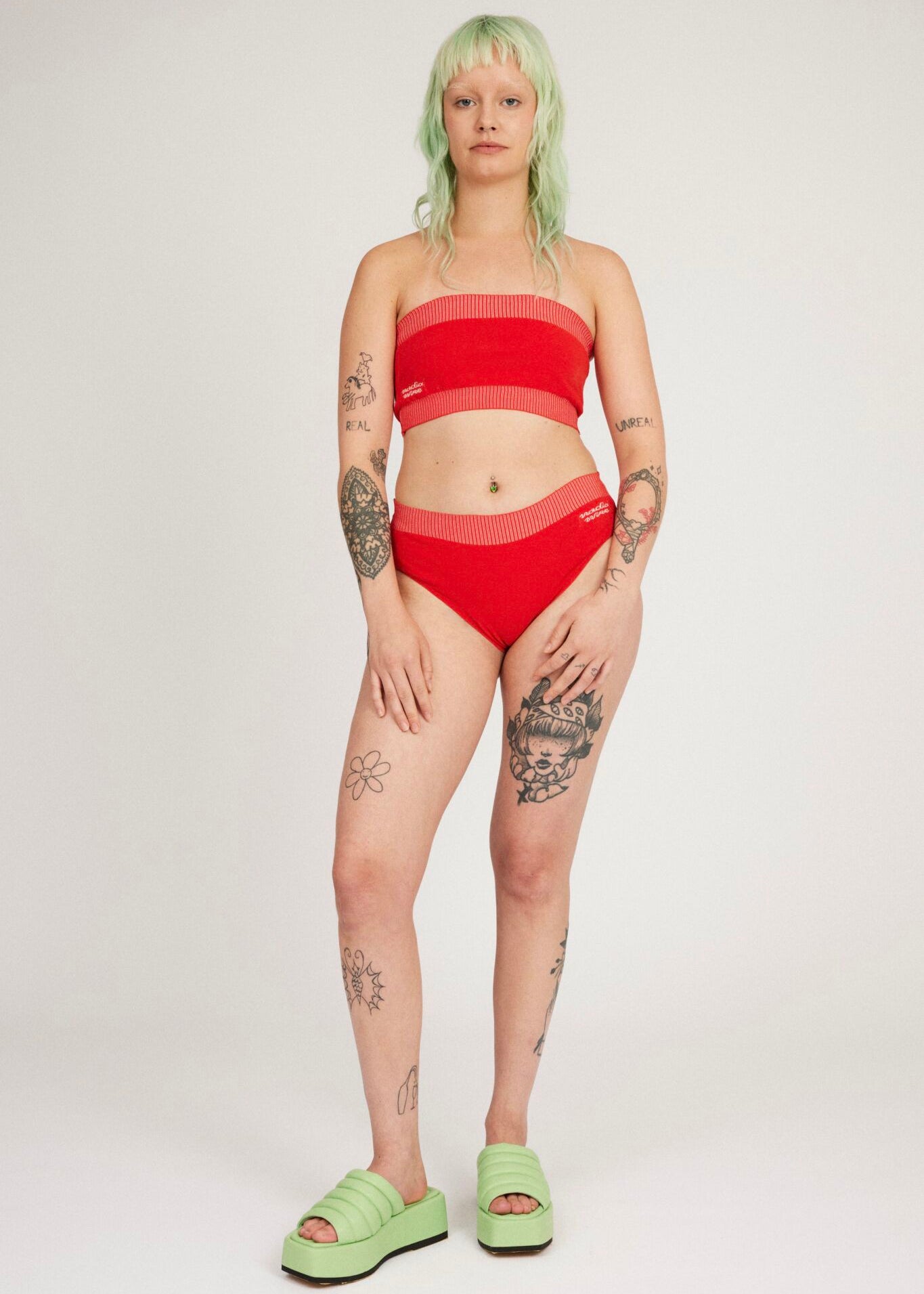 Spring Bloomer Trusse i rød og pink er et strikket par højtaljede trusser med logo og ribbede kanter. Strikket i et kropsnært, men fleksibelt materiale, der tilpasser sig kroppen. Kan mixes og matches med Spring Bloomer Top og kan bruges som badetøj.