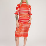 Sweet Secret Dress in coral red is a transparent knitted short sleeved high neck dress in gradient stripes with shimmery metallized yarn. The textile is lightweight, delicate and very flexible. The dress has a body fitted silhouette that adapts to the body. Detailed with frills and a logo in the back of neck.