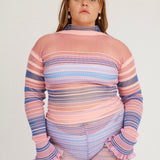 Sweet Secret Jumper in pink and powder blue is a knitted transparent high neck jumper in all over bold stripes detailed with shimmery metallized yarn. The textile is lightweight, delicate and very flexible. The jumper has a body fitted silhouette that adapts to the body. Detailed with frills and a logo in the back of the neck.