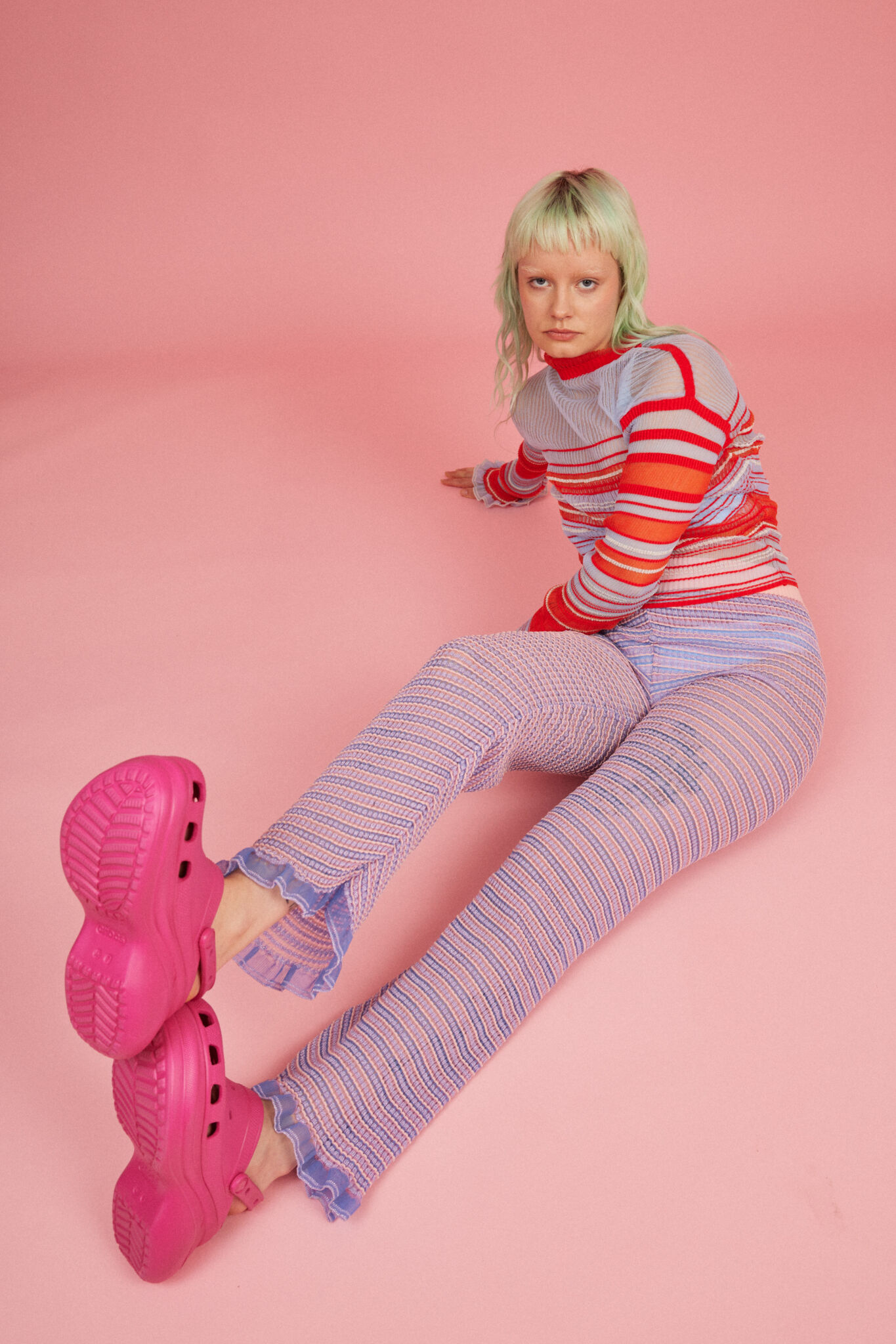 Loveable Loop shot by Amelia Lourie. Sweet Secret Jumper in coral red and Sweet Secret Trouser in pink and powder blue. Transparent and responsible knitwear clothing.