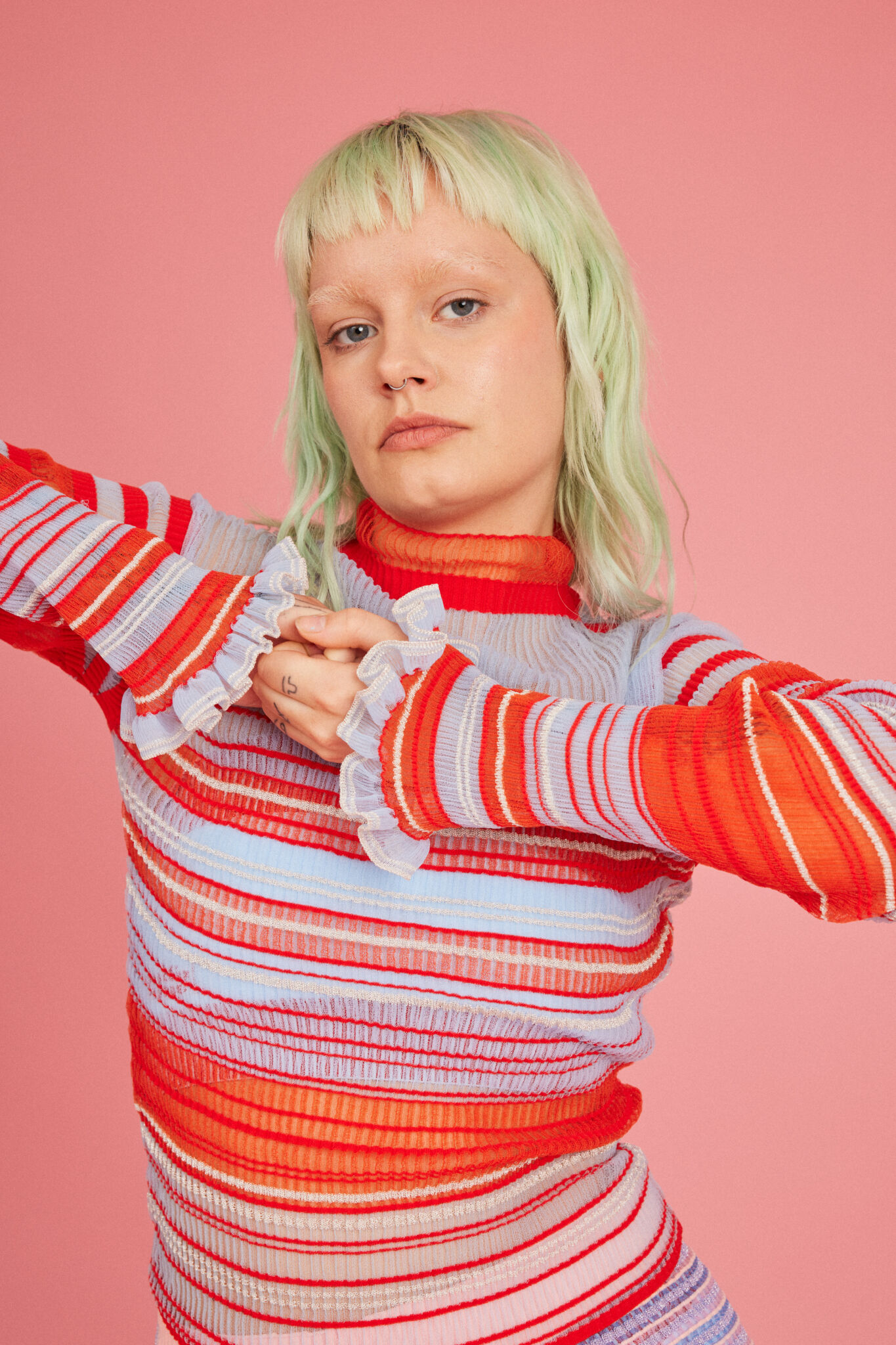 Loveable Loop shot by Amelia Lourie. Sweet Secret Jumper in coral red. Transparent and responsible knitwear clothing.