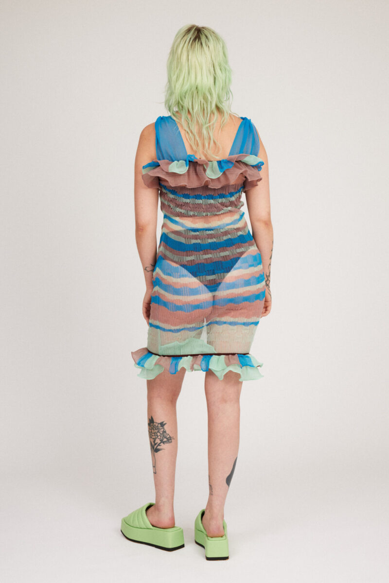Loveable Dress in blue and mint is a transparent knitted strap dress in bold stripes with a ribbed bubble texture. The textile is lightweight, delicate and very flexible. The dress has a body fitted silhouette that adapts to the body. Detailed with frills.