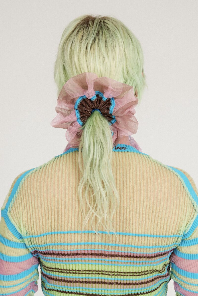 Petunia Scrunchie in tanned and pink is a knitted scrunchie in bold stripes. Made of transparent and shimmery yarns.
