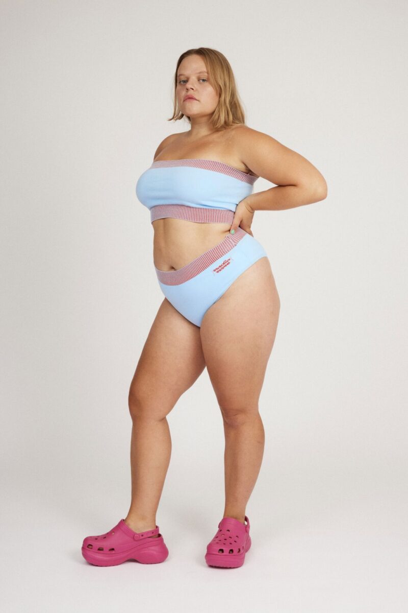 Spring Bloomer Top in light blue and red is a knitted sporty tube top with logo and ribbed edges. Knitted in a body fitted, yet flexible material that adapts to the body. Can be mixed and matched with Spring Bloomer Panty and be used as swimwear.