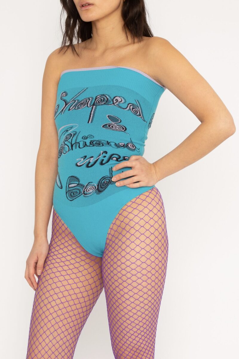 Fashioned Bodysuit in turquoise and lilac is a jacquard knitted strapless body with 3D statement artwork in bold colours. Knitted in a fitted, yet very flexible material that adapts to the body and has a slight shaping effect. Detailed with a ribbed upper rim to keep it in place. The Fashioned Bodysuit is a tribute to our core values and production methods, with the text in the front stating ”Shaped & fashioned Wire body” and the back ”Body fully fashioned & shaped in Denmark”. Fully fashioning is a waste minimizing technique used when knitting all our garments. Available in 3 different colours and sizes.
