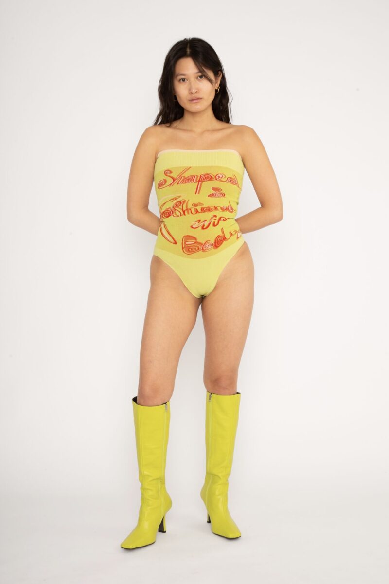 Fashioned Bodysuit in yellow and orange is a jacquard knitted strapless body with 3D statement artwork in bold colours. Knitted in a fitted, yet very flexible material that adapts to the body and has a slight shaping effect. Detailed with a ribbed upper rim to keep it in place. The Fashioned Bodysuit is a tribute to our core values and production methods, with the text in the front stating ”Shaped & fashioned Wire body” and the back ”Body fully fashioned & shaped in Denmark”. Fully fashioning is a waste minimizing technique used when knitting all our garments. Available in 3 different colours and sizes.