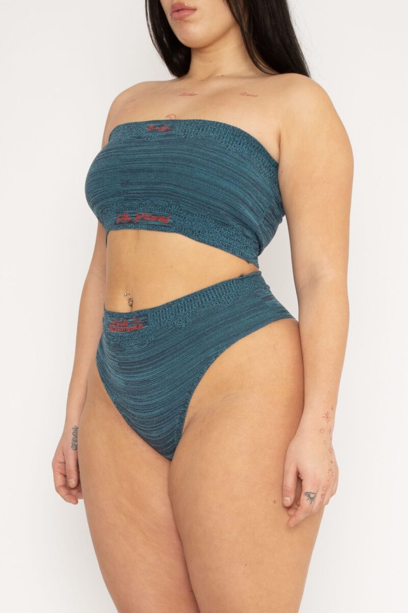 Fashioned Body Top in turquoise and navy is a knitted tube top in melange with logo, ribbed edges and statement artwork in bold colours. The textile is body fitted, yet very flexible – therefore, the tube top adapts to the body. It can be mixed and matched with Fashioned Body Panty and be used as both swimwear and everyday bodywear. The Fashioned Body Top is a tribute to our core values and production methods, with the text in the front stating ”Body fully fashioned”. Fully fashioning is a waste minimizing technique used when knitting all our garments. Available in 3 different colours and sizes.