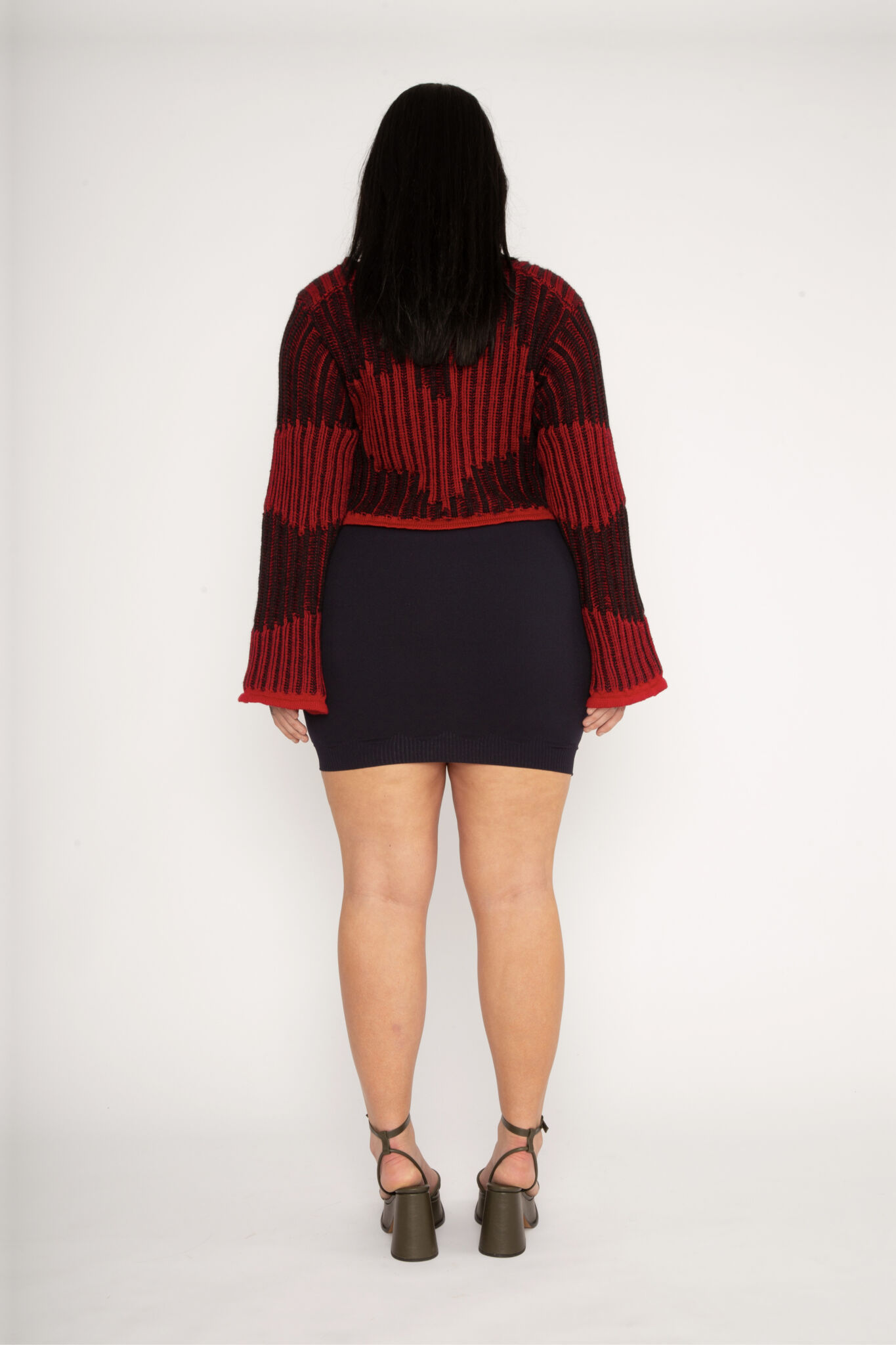 Wavy Wool Cardigan in red and black is a knitted cropped mohair cardigan with flared sleeves and all-over wavy stripes. Detailed with a heart in the back. The cardigan has a ribbed V-shaped neckline, a three-button closure and is cut for a slightly loose fit. The textile is fluffy, non-itchy and comfortable against the skin. The Wavy Wool Cardigan is also available in turquoise and comes in 3 different sizes.